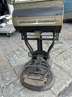 Front view of the large antique brass and iron scale showing the weighing platform and the branded brass panel.