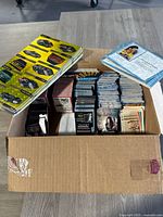 Card box open showing target contents inside on a table with stacks of cards vertically organized