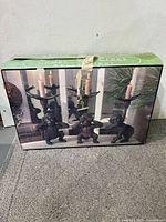 Photo of the Cedar Creek branded green box showing the three monkey candleholders each holding a candle, new in box.