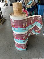 Large vintage roll of Good Humor Bubble Bill ice cream labels standing approximately 4 feet tall with visible colorful labels featuring a cartoon character and text.