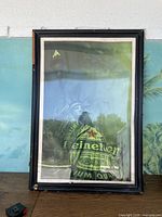 Full framed poster showing Statue of Liberty with Heineken beer label imposed, overall view, showing frame and glass with reflections