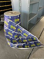 Large roll of vintage Good Humor Fat Frog ice cream labels standing about 4 feet tall, showing label design and size of roll.