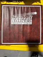 Front cover of large reddish-brown binder labeled 'Baseball Collectors Trading Cards'