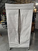 Front view of rolling wardrobe rack with grey fabric cover showing missing zipper