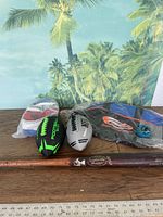 Overview of all sports items in lot including wooden bat, mini footballs, balls and carry bag.