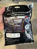Front of packaging showing brand LUOYIMAO and product title "Universal Car Seat Storage Mesh Organizer" with images of it installed in car between seats.