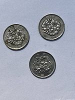 Three Japanese 100 yen coins showing Sakura flowers design on front side