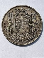 Reverse side of the 1944 Canadian 50 cent silver coin displaying the coat of arms, denomination, country, and year.