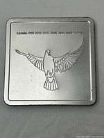 Metal tin with embossed dove and year markings 1999-2000.