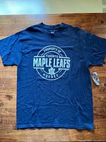 Front view of navy blue Toronto Maple Leafs T-shirt showing logo and text print.