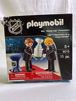 Front view of Playmobil NHL Stanley Cup Presentation set box, showing product image with two figures holding Stanley Cup trophy and presentation table.