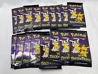 Front view of 17 unopened Pokémon Trick or Trade card booster packs laid out, showing packaging design and quantity