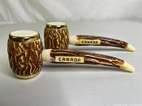 Two plastic pipe-shaped salt and pepper shakers with faux stag horn handles labeled Canada.