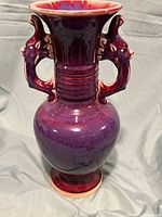 Full front view of vase showing overall shape, glaze color gradation, and bird‐form handles