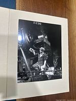Photo showing a black and white picture of a man inspecting large locomotive 2230