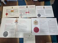 Overview photo of Canadian constitutional documents and official ceremonial papers showing seals, flags and government crests.