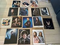 Overview of 14 signed 8x10 photos laid on floor, showing various celebrities including characters from Lord of the Rings, Catwoman, and others.