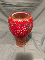 Front view of the red Chinese vase showing cut-out floral pattern and colorful painted floral decorations