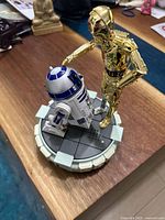 Star Wars limited edition figurine with C-3PO touching R2-D2 on a sci-fi platform base, photographed from top angle showing details.