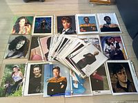Large group of 10x8 celebrity autographed photos, laid out on floor, showing varied signatures and images of different celebrities