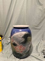 Front view of blue ceramic vase with floral painted design