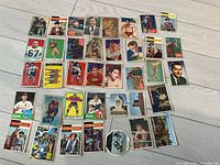 Photo showing an assortment of vintage hockey and other trading cards laid on a light wood floor.