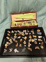 Overview of Wade Whimsies figurines laid out on a tray with carrying case box open behind them