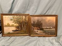 Pair of framed oil paintings on canvas against draped cloth background