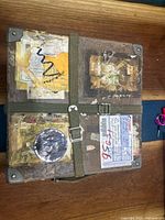 Closed view of the vintage carrying case showing extensive tape and label damage, secured with olive green strap.