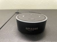 Front view of the Amazon Echo Dot device showing Amazon logo and control buttons on top.