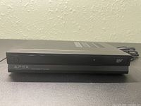 Front view of Apex DT250 digital TV converter showing power button, Apex logo, and DTV label.