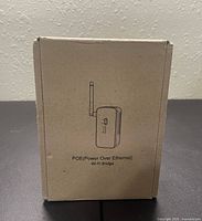 Photo of the closed cardboard packaging box with illustration of the WiFi Bridge and text 'POE (Power Over Ethernet) Wi-Fi Bridge'.