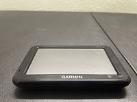 Front view of Garmin NUVi 2495LMT GPS with screen and logo visible, showing some signs of use.
