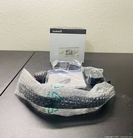 Top-down photo showing the Garmin box and watch accessories laid out with bubble wrapped item in front.