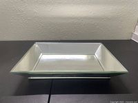 Top-down view of square glass dish mirror showing beveled edges and reflective surface