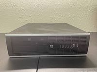 Front view of the HP desktop computer with visible optical drive, USB ports, and audio jacks on front panel.