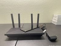 Top view of the TP-Link Archer AX55 wireless router showing design, antennas, and power cord neatly coiled beside device.