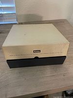 Closed Kodak storage box showing Kodak logo and product details, beige top and black base.