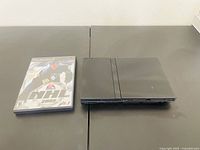 Sony PlayStation 2 console placed next to NHL Hockey 2002 game case on table surface, showing overall cosmetics and contents of lot.