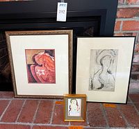 Three framed art pieces on brick surface: two large prints and one small 5x7 framed print centered in front.