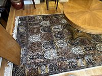 Whole rug laid out under table showing overall pattern and condition