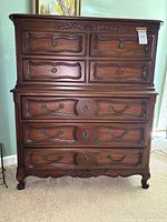 Front view of Drexel chest of drawers showing 2 small upper drawers and 4 larger drawers below, dark wood with decorative carved inlay and classic metal handles