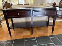 Front view of dark wood console table showing two drawers with metal knob pulls and lower shelf.