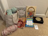 Photo showing yarn skeins in collapsible wood framed yarn bag and assorted craft books