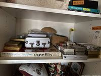 Vintage Aggravation board game box on shelf with other card decks and games visible