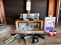 Full overview of lot showing oil containers, Lubriplate tubes, metal box with plastic bagged wall hooks, combination square and level, and metal rulers.