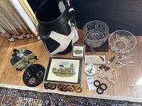 Golf-themed decor including plates, trophies, plaques, glass bowls, and wooden rings arranged on a hardwood floor near curtains.