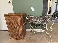 Photo of the natural wicker laundry basket and vintage makeup chair side by side against a green wall