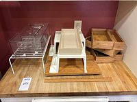 Image of clear acrylic organizing container, white and beige trays, bamboo trays, and wooden cutting board displayed together.