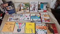 Photo showing 14 books on drawing and creativity arranged on a surface including titles like The Art of Urban Sketching, Creative Block, and Colored Pencil Solution Book.